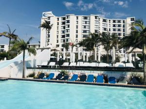 德班Breakers Resort Apartments的一座带椅子的游泳池和一座建筑的酒店