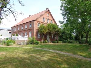 克鲁姆赫恩Apartment Muschel im Gästehaus Heeren的一座带草地庭院的大型砖砌建筑