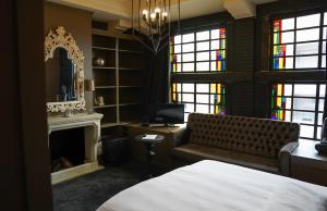 阿尔梅罗比瓦林之家的一间卧室设有一张床、一个壁炉和彩色玻璃窗
