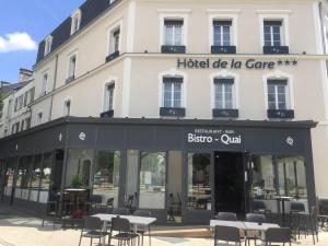 永河畔拉罗什Hôtel de la Gare - Restaurant Bistro Quai的一座带桌椅的De la care酒店