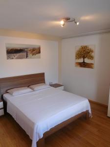 科尔丘拉Villa Marija的卧室配有白色的床,墙上挂着一棵树