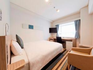 东京Shinagawa Prince Hotel N Tower的一间卧室配有一张床、一张桌子和一把椅子