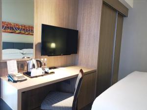 新山KSL温泉度假酒店的酒店客房配有一张书桌、一台电视和一张床