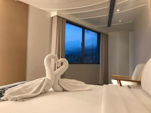 淡水欧朋仑旅店的酒店客房的床上配有2条天鹅毛巾