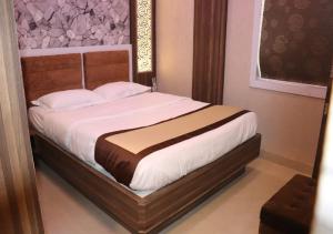 加尔各答Hotel Angina的一间卧室配有一张带白色床单的大床
