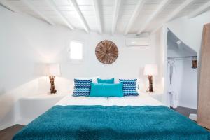 米克诺斯城Absolute Mykonos Suites & More的白色卧室配有蓝色枕头的床
