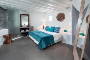 米克诺斯城Absolute Mykonos Suites & More的白色卧室配有床和镜子