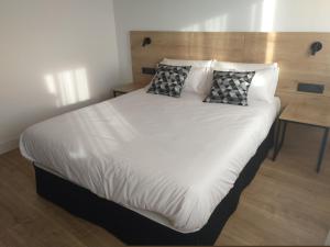 卡萨拉雷纳Hotel Entrerailes的一张带两个枕头的大白色床