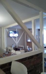 萨顿布里奇The Boathouse的一间带桌椅和电视的用餐室