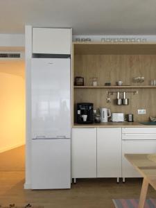 阿利坎特Hola Hostel Alicante的厨房配有白色橱柜和白色冰箱。