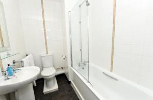 霍伊莱克Green Lodge, Wirral by Marston's Inns的浴室配有卫生间、盥洗盆和浴缸。