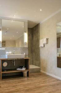 里姆斯廷格太阳酒店的一间带水槽和镜子的浴室