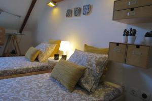 萨尔堡Casa do Largo的一间卧室配有两张床和一张带台灯的桌子