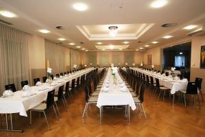 萍卡菲尔特平卡费尔德斯塔迪特酒店的一个带白色桌椅的大型宴会厅