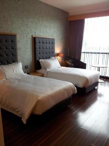 怡保欣悦酒店的酒店客房设有两张床和窗户。