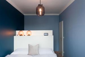 林茨URBANAUTS FLATS Cubierta的卧室拥有蓝色的墙壁和白色的床。