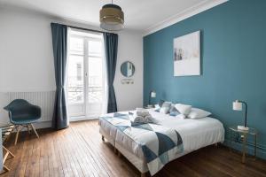 南特Le Prestige by Cocoonr的蓝色卧室,配有床和椅子