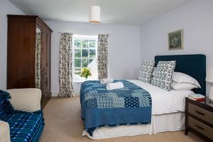 勒兰蒂德威尔斯The Old House, Llwyn Madoc的卧室配有蓝色和白色的床和窗户。
