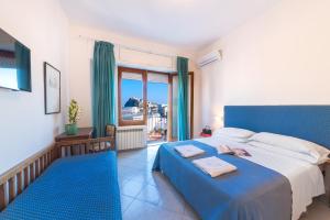 伊斯基亚欧洲大酒店 的一间卧室设有蓝色的床和一个阳台