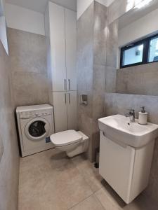 波别罗沃Apartament MALIBU - Aprent的浴室配有卫生间水槽和洗衣机。