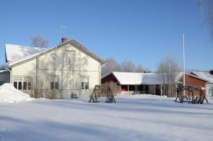 豪基普达斯Lomakoti Onnela的一座白房子和一座建筑的雪覆盖的院子