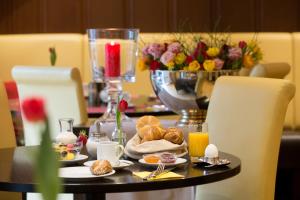美因河畔法兰克福迈伽酒店的一张桌子,上面有食物和饮料,桌子上还有鲜花