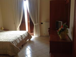梅尔卡托圣塞韦里诺橄榄山乡村别墅旅馆的一间卧室设有一张床、一台电视和一个窗口。