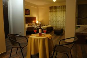 伊察hotel el parral suite的一间酒店客房,配有一张桌子和两杯葡萄酒