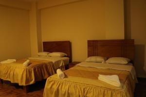 伊察hotel el parral suite的客房内的两张床和毛巾