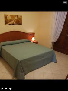 梅尔卡托圣塞韦里诺橄榄山乡村别墅旅馆的一间卧室配有一张带绿床罩的床