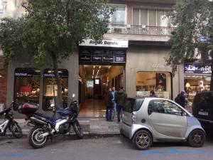雅典TONI'S Studio Syntagma, 1 min from Metro station的停在商店前面的摩托车和小汽车