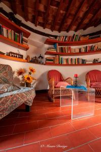 福利亚Mulino a vento的客厅配有两把椅子和一张桌子,并提供书籍