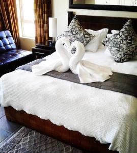 德班Rostalyn Guesthouse的一张带两个天鹅的毛巾床