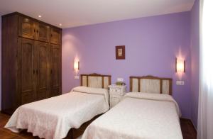 纳维亚苏琴乡村酒店的紫色墙壁客房的两张床