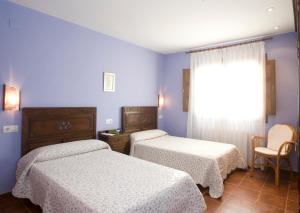 纳维亚苏琴乡村酒店的配有两张床铺的蓝色墙壁和窗户