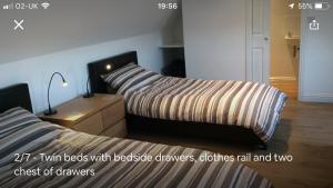 HollingwoodThe Loft的一间卧室配有两张床、毯子和一张书桌