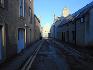 柯克沃尔Orkneyinga的建筑物之间的小巷里一条空的街道