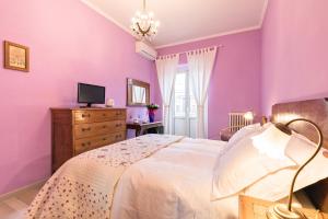 罗马罗马故事住宿加早餐旅馆的一间卧室设有紫色的墙壁、一张床和一台电视机。