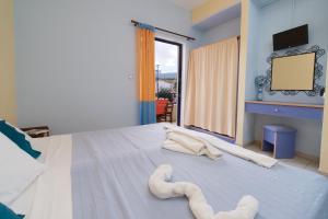 凯法利尼亚岛Kalypso Studios & Apartments的一间卧室配有一张大床和毛巾
