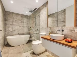 悉尼Tamarama Apartments的带浴缸、卫生间和盥洗盆的浴室
