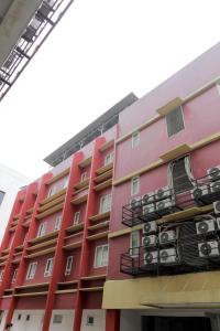 贝克西RedDoorz Plus near Galaxy Bekasi的阳台上配有空调的红色建筑