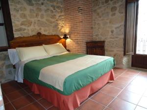 坎德拉里奥普埃尔塔波萨达大旅馆的卧室设有一张砖墙内的大床