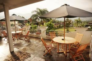 巴图Villa Cemara的一个带桌椅和遮阳伞的庭院