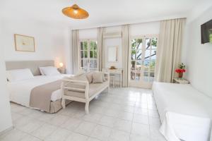 Ambrami佩特里诺酒店的白色卧室配有两张床和一张沙发
