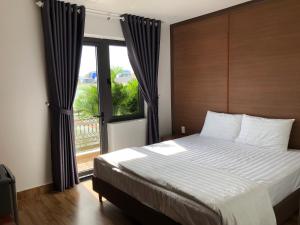 金兰HOÀNG SA HOTEL的一间卧室设有一张大床和一个大窗户