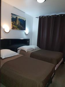 马赛胜利酒店的酒店客房设有两张床,墙上挂有绘画作品