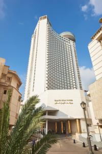 开罗尼罗河大厦酒店的一座高大的白色建筑,前面有一棵棕榈树