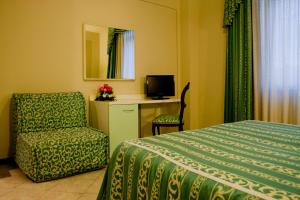 雷扎托米开朗基罗酒店的一间卧室配有一张床、一把椅子和电视