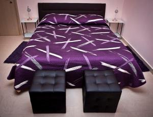 斯普利特Split Apartments Peric的一张带紫色棉被和一对座位的床