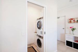 努萨维尔Durramboi Luxury Apartment的白色洗衣房配有洗衣机和烘干机